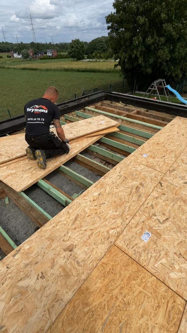 Ouvrier posant des panneaux OSB sur une ossature bois